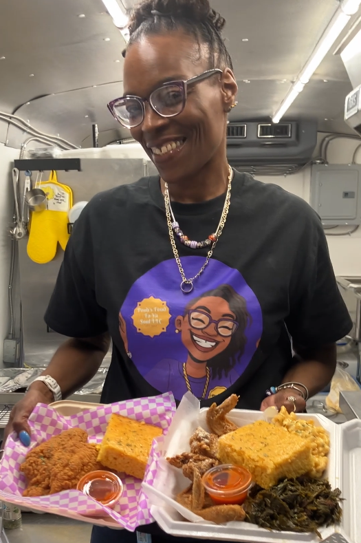 Pooh holding trays of fresh soul food in her kitchen